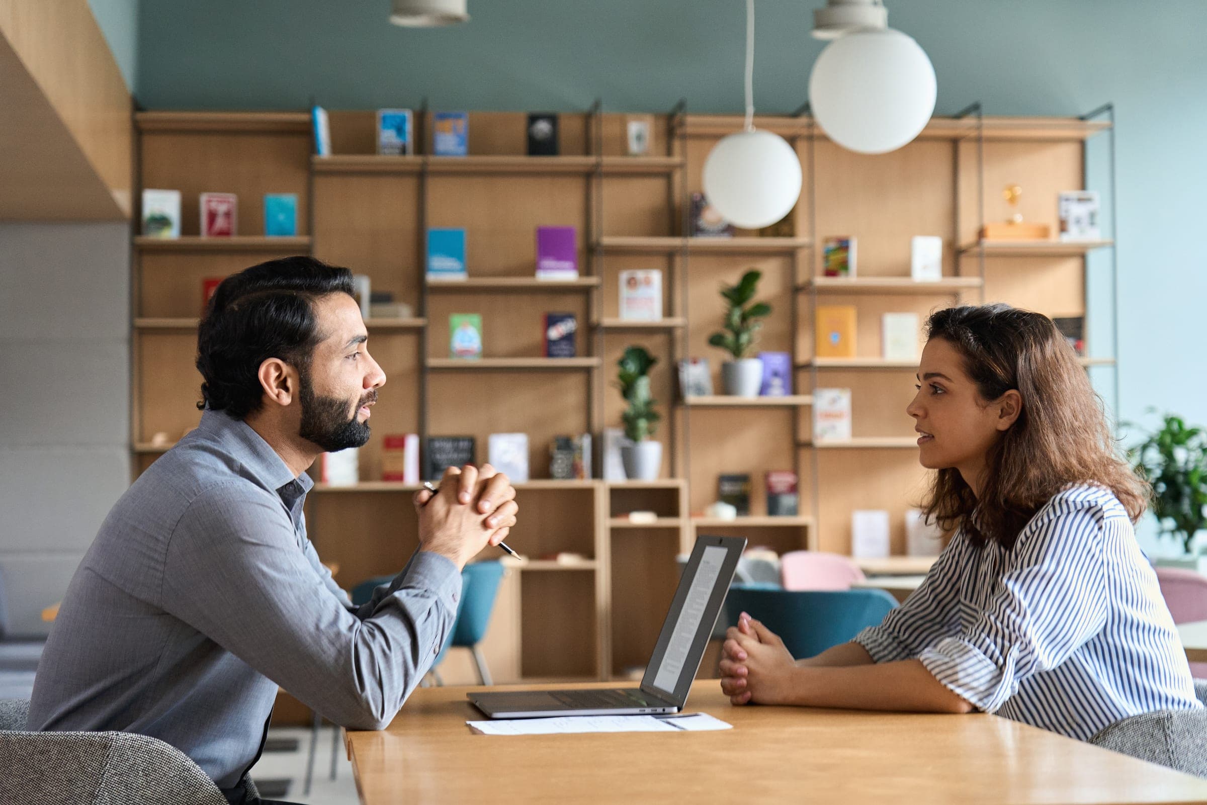 Two colleagues having a focused, respectful conversation across a table